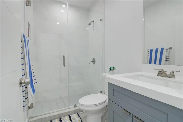Bathroom with walk in shower, toilet, and vanity