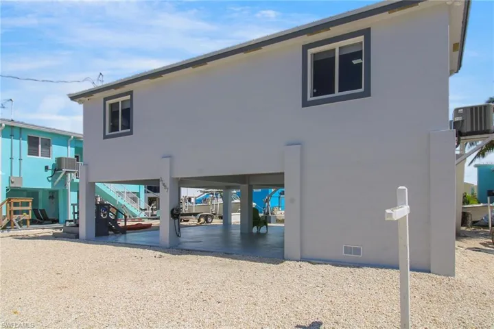 Rear view of property with cooling unit