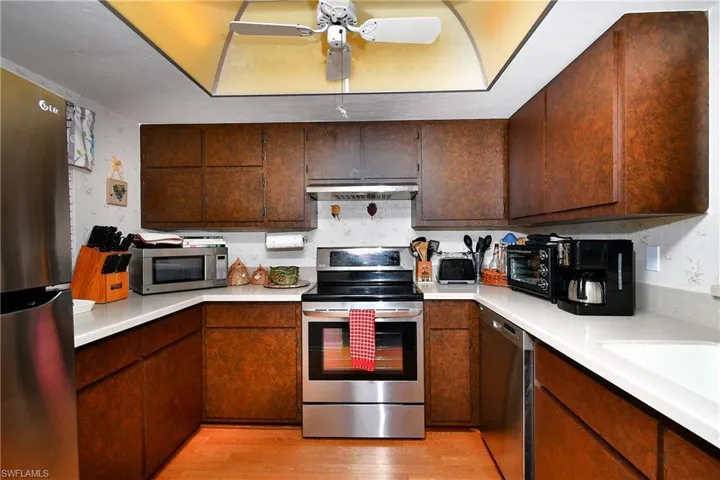 Kitchen with ceiling fan, appliances with stainless steel finishes, sink, and light wood-type flooring