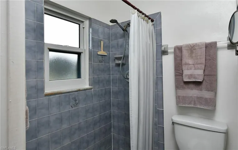 Bathroom with toilet and a shower with shower curtain