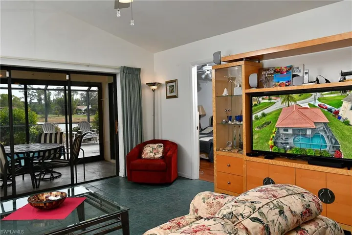 Living room featuring ceiling fan and lofted ceiling