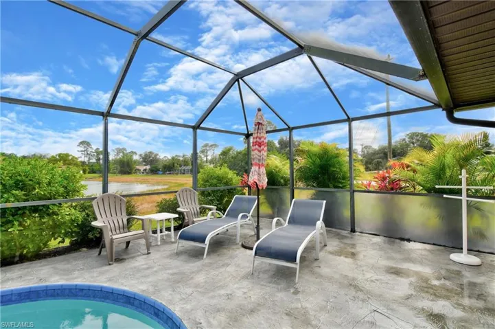 View of patio featuring a water view and glass enclosure