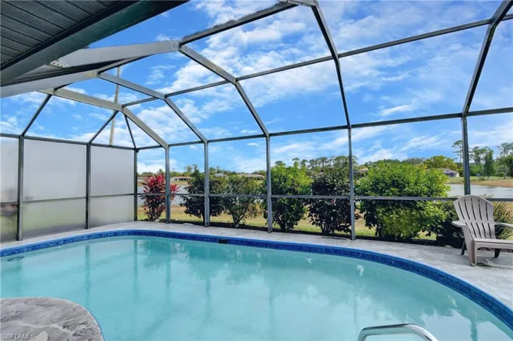 View of swimming pool with a patio and glass enclosure