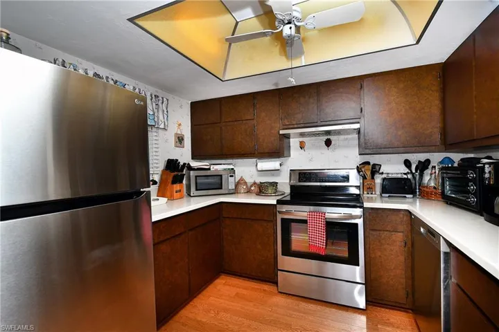 Kitchen featuring dark brown cabinets, light hardwood / wood-style flooring, stainless steel appliances, and ceiling fan