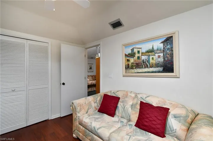 Living room with lofted ceiling, dark hardwood / wood-style floors, and ceiling fan