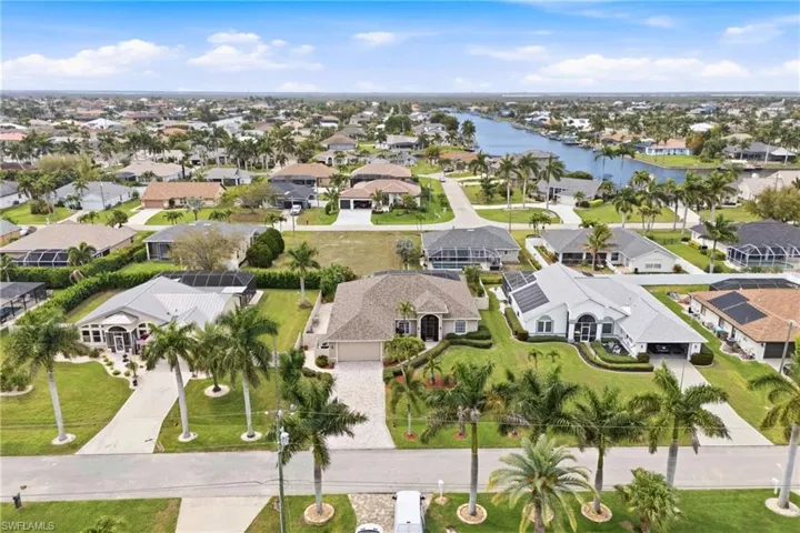 See your Florida paradise from above—beautiful front façade, manicured lawn, and welcoming entrance.
