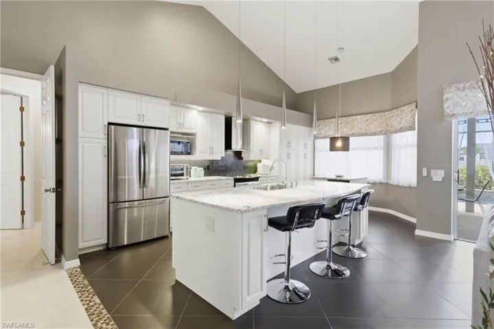 Chef-inspired perfection! Custom cabinetry with pull-out shelves, granite countertops, stainless appliances, and a sunlit island make every meal a delight.