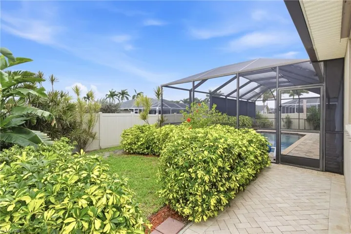 Your private tropical oasis—lush greenery surrounds a sparkling screened pool for ultimate relaxation.