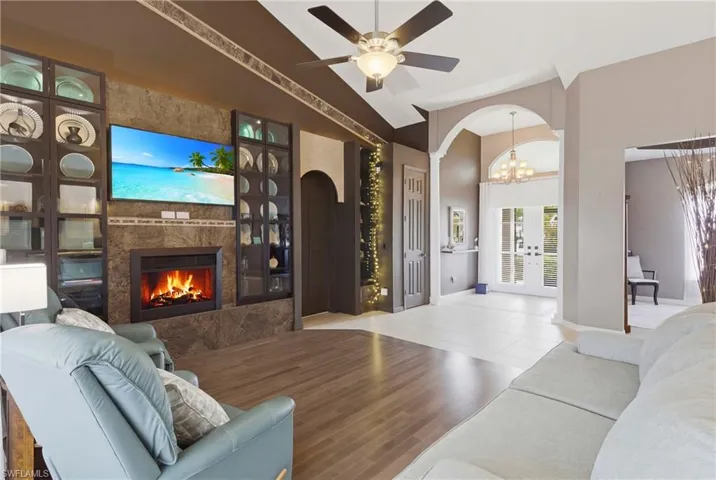 Soaring 16-foot cathedral ceilings, rich hardwood floors, and a custom entertainment wall create a stunning centerpiece for entertaining or relaxing in style.