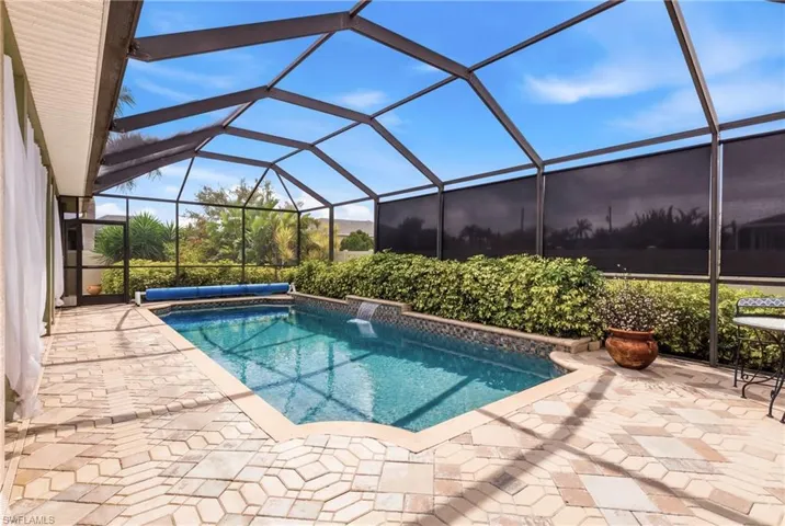 Your private tropical getaway—heated pool with waterfall, surrounded by lush landscaping and seamless pavers connecting the lanai to your driveway.