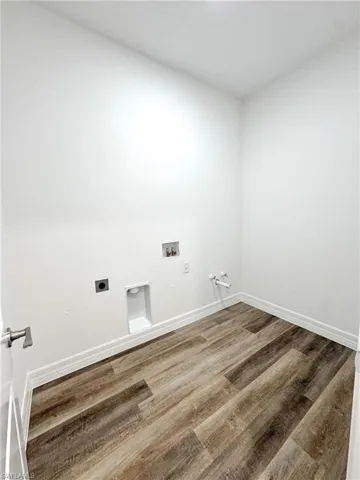 Laundry room featuring hookup for a gas dryer, hookup for an electric dryer, washer hookup, and wood-type flooring