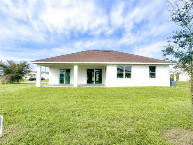 Back of property featuring a patio area and a lawn