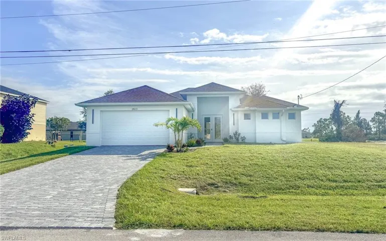 View of front of house featuring a front yard and a garage