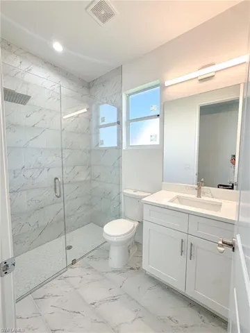 Bathroom #2 with vanity, toilet, and a shower with shower door
