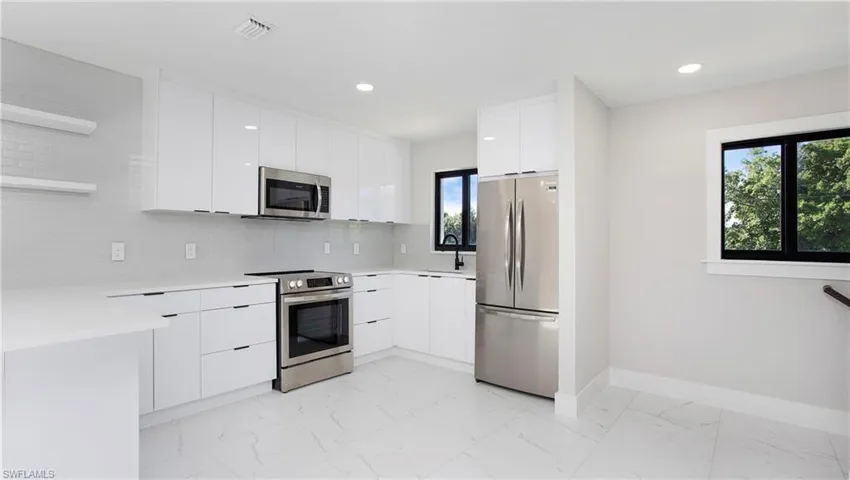 Kitchen with open shelves, modern cabinets, white cabinetry, stainless steel appliances, and tasteful backsplash