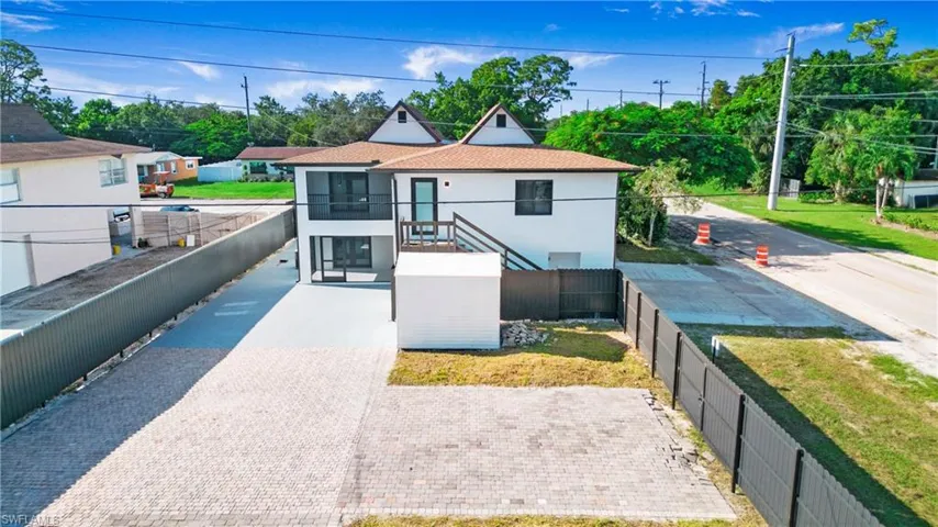 View of front of house featuring a fenced backyard, stucco siding, driveway, a balcony, and a shingled roof