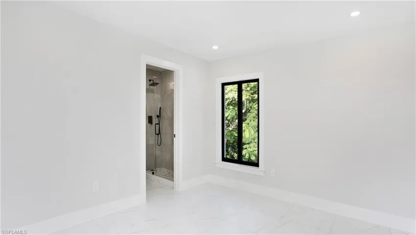 Empty room featuring light marble finish flooring and recessed lighting