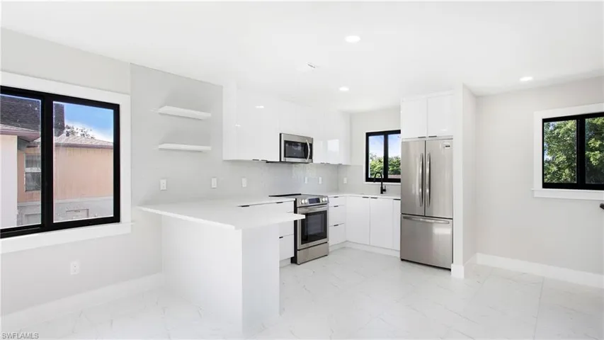 Kitchen with open shelves, modern cabinets, stainless steel appliances, white cabinets, and decorative backsplash