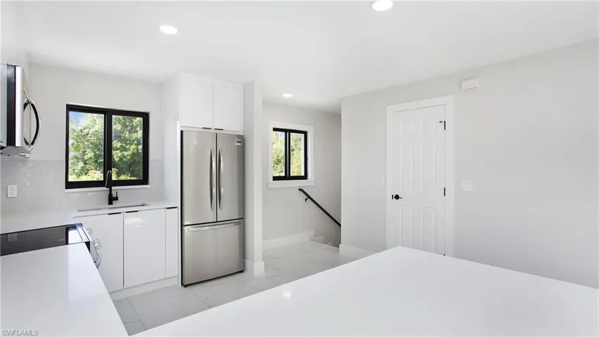 Kitchen featuring stainless steel appliances, white cabinetry, modern cabinets, healthy amount of natural light, and recessed lighting