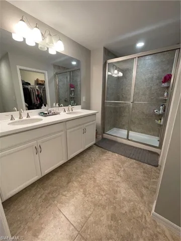 Bathroom with a sink, tiled shower, and tile patterned floors