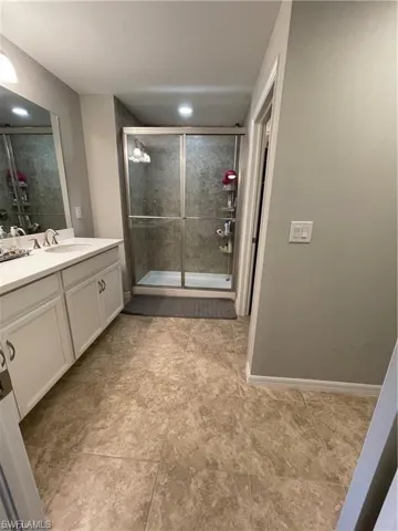Full bath featuring vanity, a shower stall, and tile patterned flooring