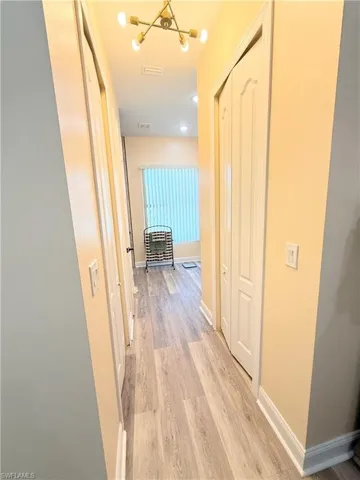 Hall with baseboards and light wood-type flooring