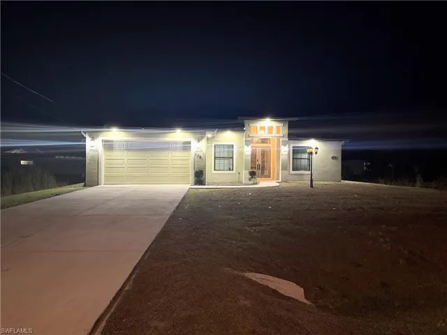 View of front facade featuring concrete driveway, an attached garage, and stucco siding