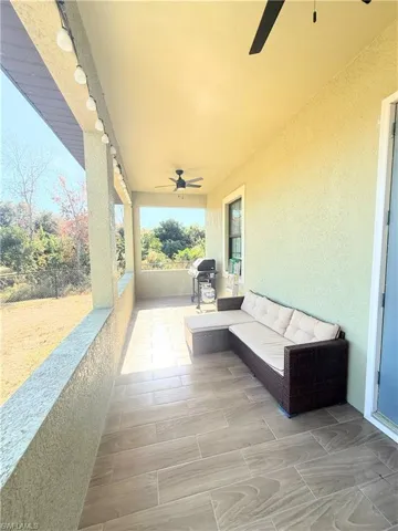 View of patio with ceiling fan, grilling area, and an outdoor hangout area