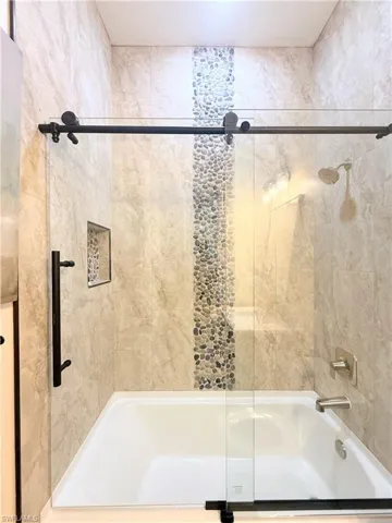 Bathroom with combined bath / shower with glass door