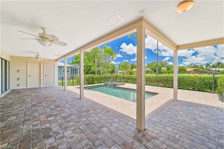 View of patio with ceiling fan, fence private yard, and a pool with connected hot tub