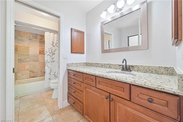Full bathroom with shower / bath combination with curtain, vanity, and toilet
