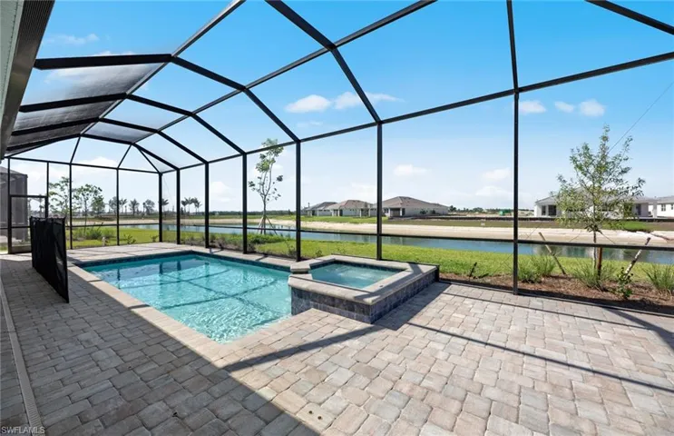 View of pool featuring glass enclosure, an in ground hot tub, and a patio area