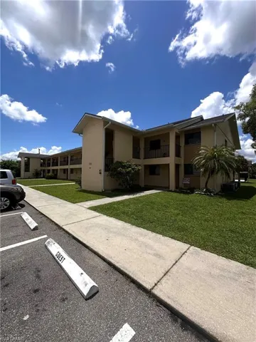 View of property featuring uncovered parking