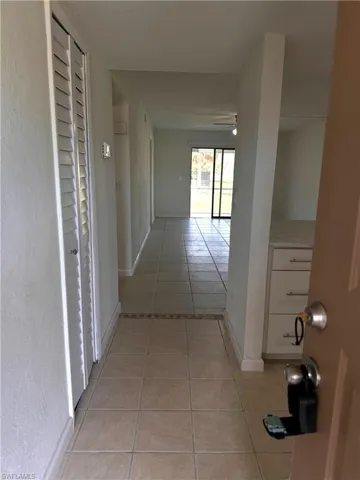 Corridor with light tile patterned floors and baseboards