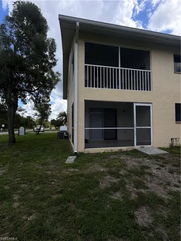 Back of property with stucco siding and a lawn