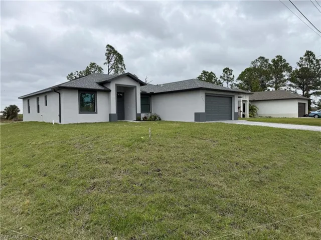 View of front facade with a front lawn and a garage