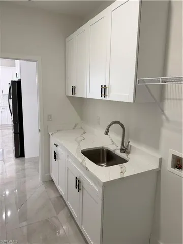 Laundry room with cabinets, sink, and hookup for a washing machine