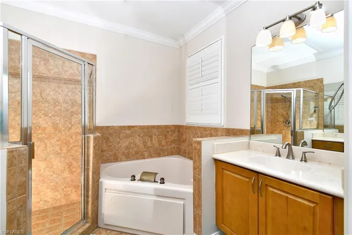 Master bathroom featuring crown molding, vanity, and plus walk in shower