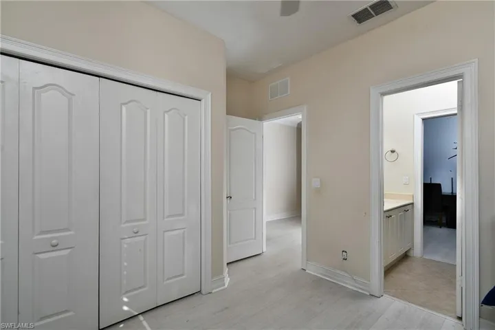 Bedroom featuring ensuite bath, light hardwood / wood-style floors, and a closet