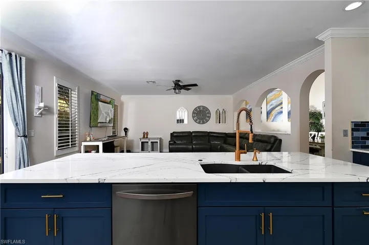 Kitchen featuring sink, blue cabinetry, an island with sink, and dishwasher