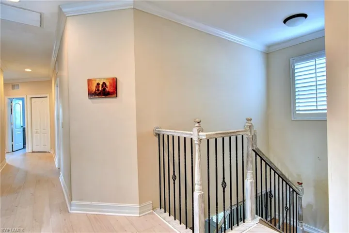 Hallway featuring ornamental molding and light hardwood / wood-style floors