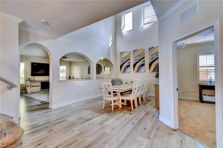 Dining area featuring crown molding, plenty of natural light, and light wood-type flooring