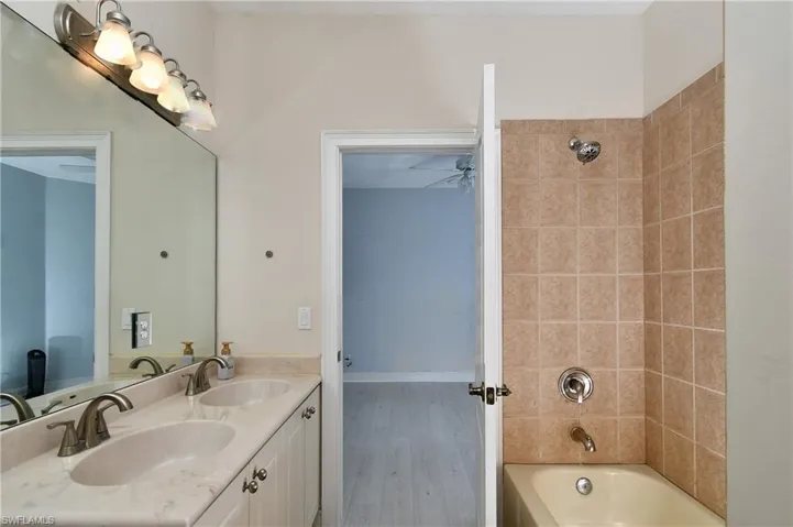 Bathroom with ceiling fan, vanity, and tiled shower / bath combo