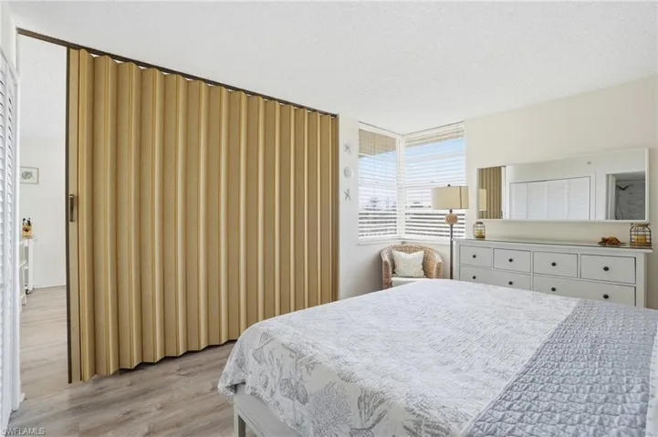 Bedroom featuring wood-finish flooring and a neutral color palette - Virtually Edited Image
