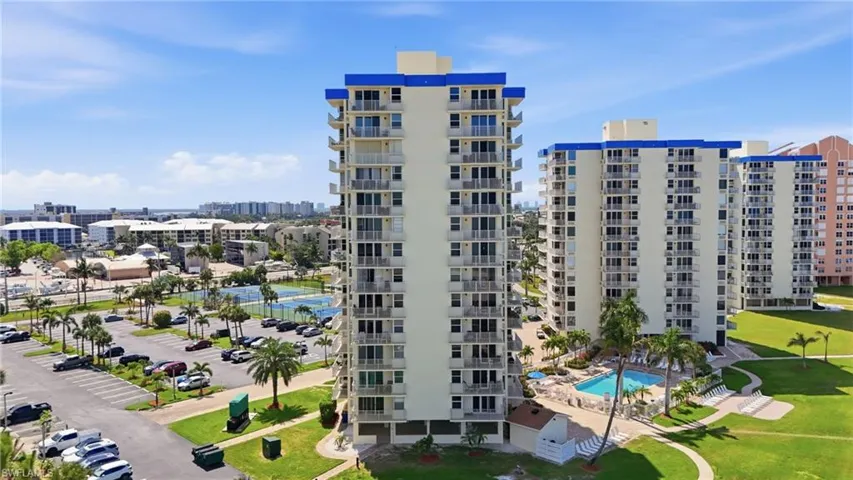 High-rise residential building featuring multiple balconies and a prominent blue roofline - Virtually Edited Image