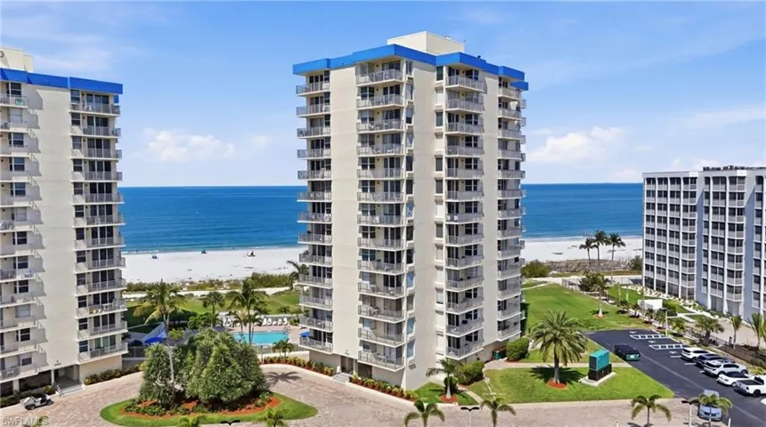 Multi-story residential complex featuring private balconies and a blue roofline accent - Virtually Edited Image