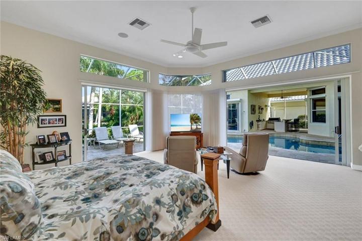 Primary bedroom with sliding glass doors leading out to the pool/lanai area.