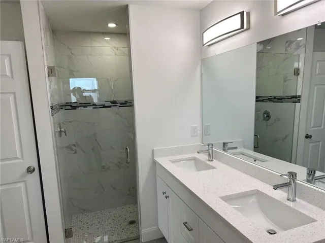 Bathroom with vanity and a shower with shower door