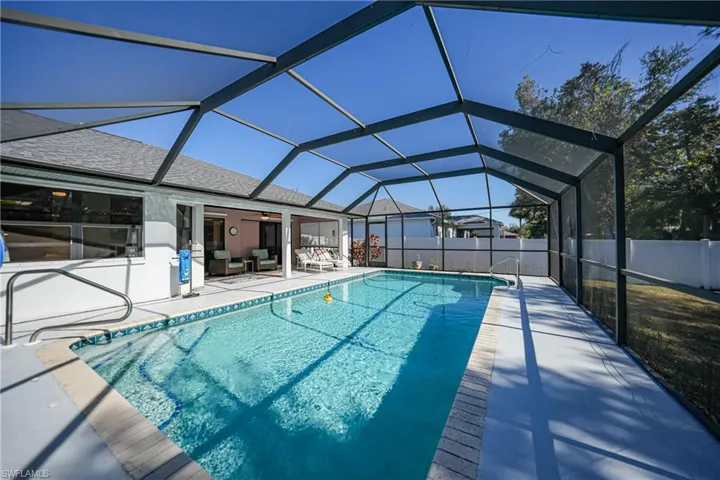 View of swimming pool featuring ceiling fan, a lanai, and a patio