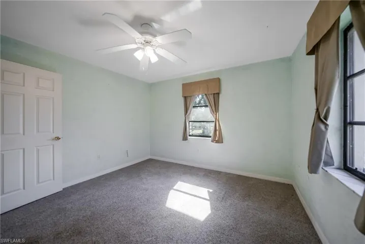 Carpeted spare room featuring ceiling fan